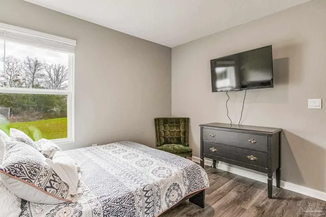 a bedroom with a bed and a large window with outer view