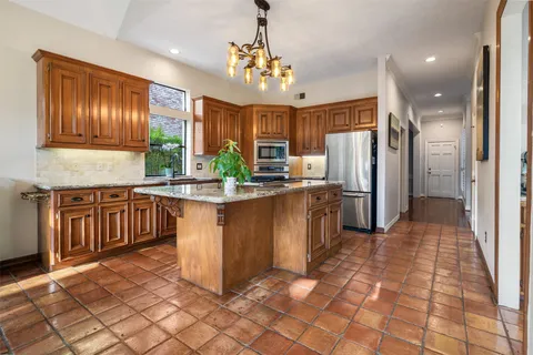 a kitchen with stainless steel appliances granite countertop a refrigerator a oven a sink and dishwasher