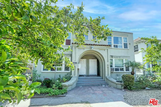 a front view of a house with plants