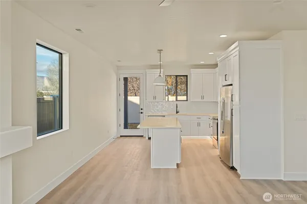 a kitchen with white cabinets and appliances