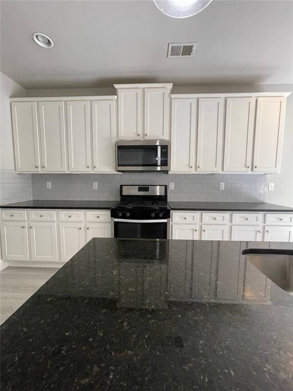 2325 Haliard Way Lithonia, GA 30058 - Photo 12 of 36 a kitchen with granite countertop white cabinets and stainless steel appliances
