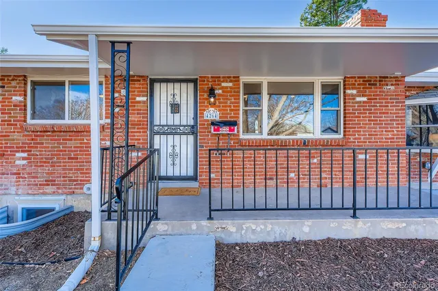 a view of a brick house with wooden fence