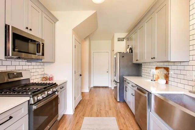 a kitchen with stainless steel appliances a stove sink microwave and cabinets