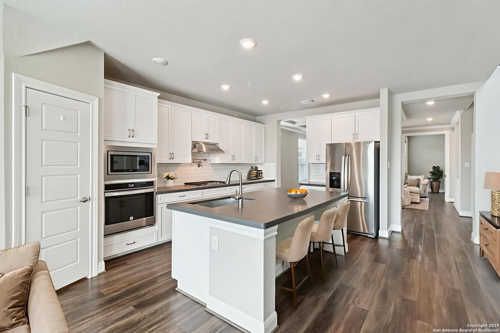 2622 Raven Ridge Point San Antonio, TX 78259 - Photo 6 of 53 a kitchen with stainless steel appliances a stove a sink and a refrigerator
