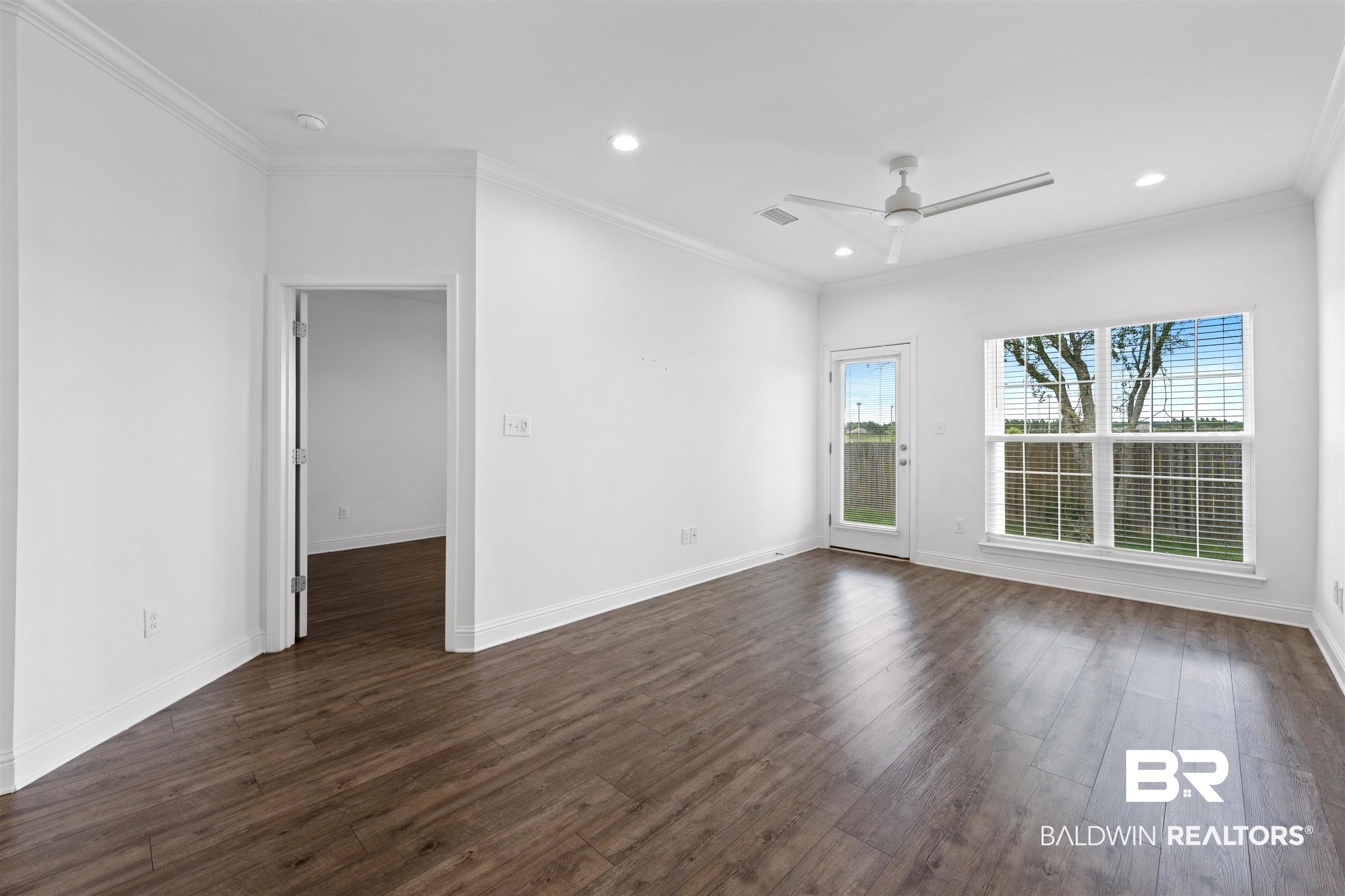 2651 South Juniper Street, Unit 1801 Foley, AL 36535 - Photo 6 of 16 Spacious room featuring wood-finish flooring, white walls, and crown molding