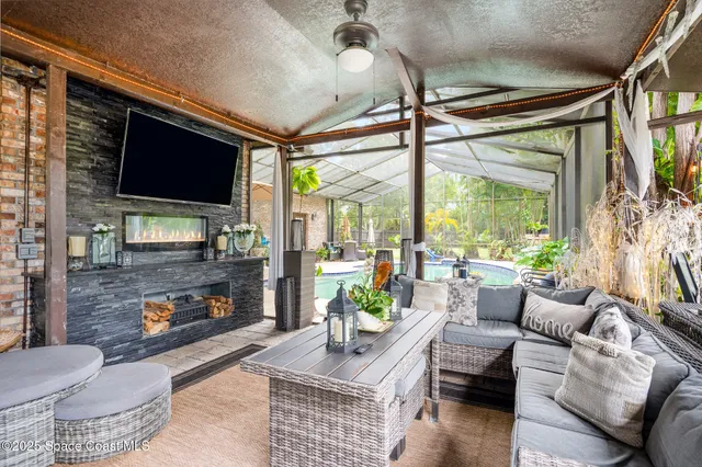a living room with furniture a flat screen tv and a floor to ceiling window