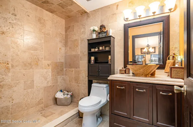 a spacious bathroom with a granite countertop toilet sink and mirror