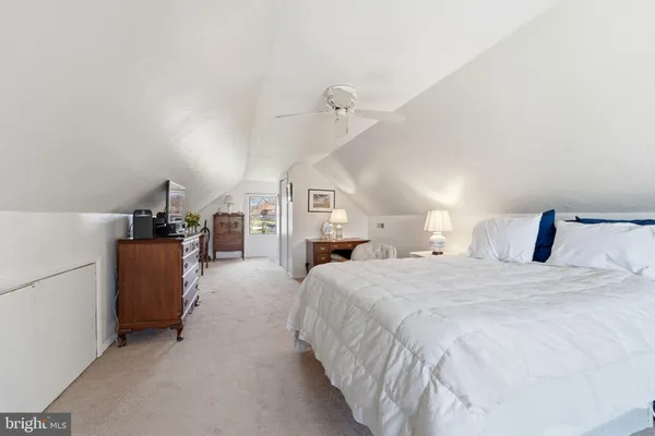 a spacious bedroom with a bed and a chandelier