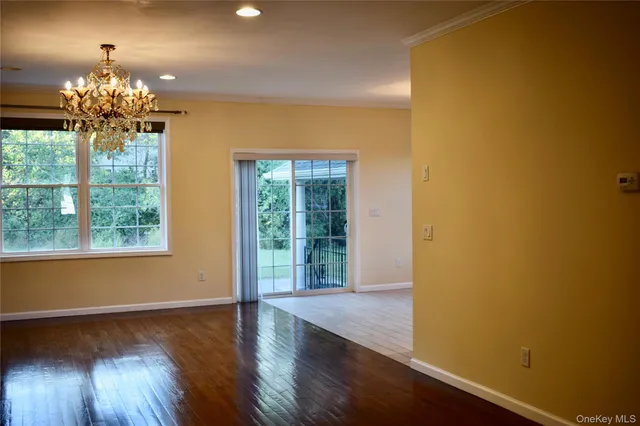a view of a room with wooden floor and chandelier