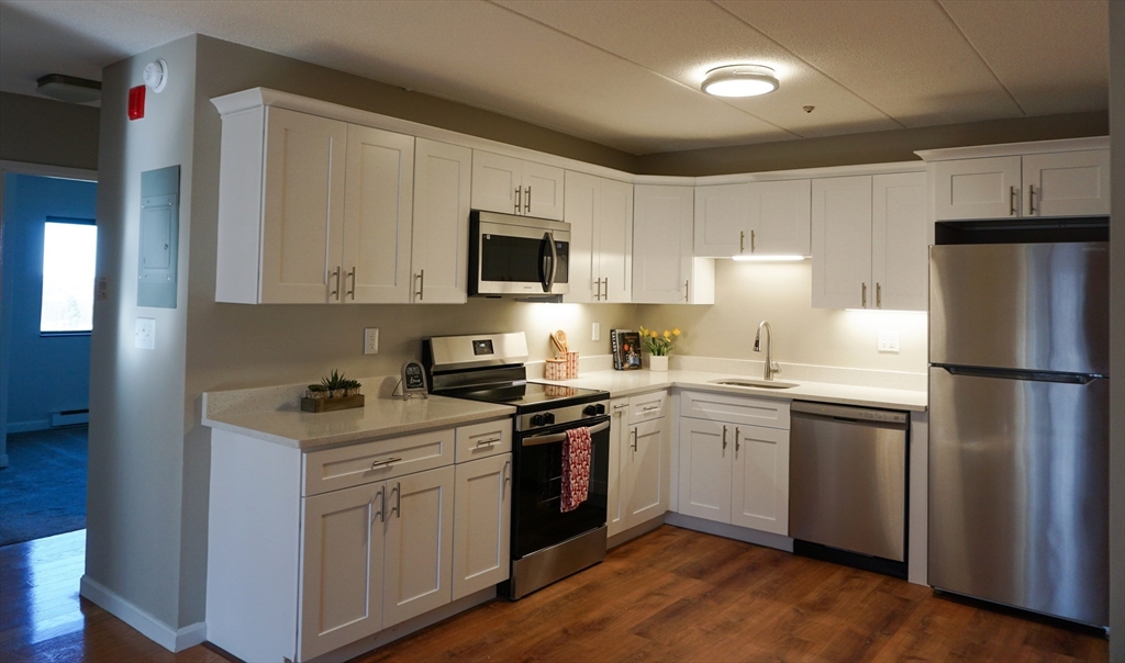 a kitchen with a sink a stove a refrigerator and cabinets