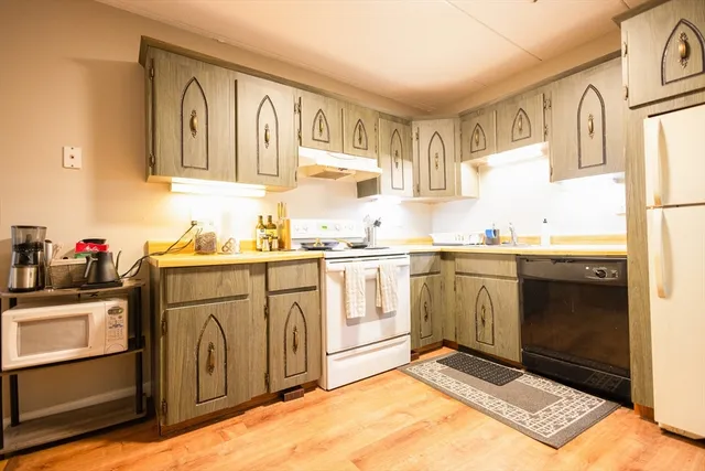 a kitchen with granite countertop a sink cabinets and stainless steel appliances