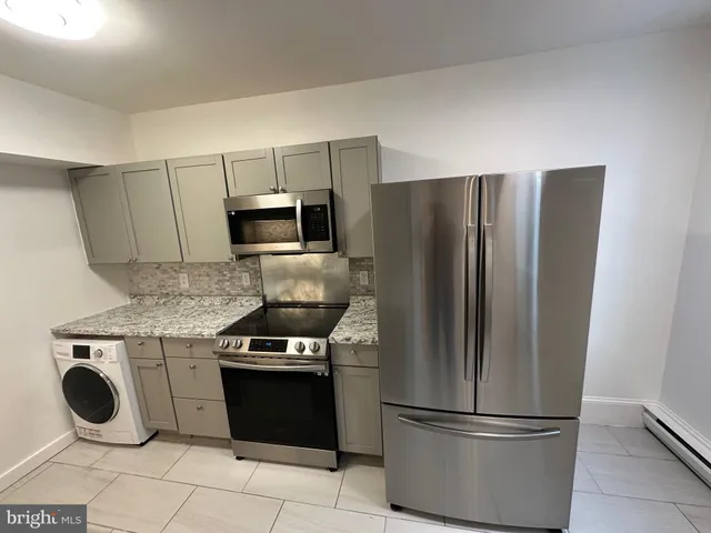 a kitchen with granite countertop stainless steel appliances and a refrigerator