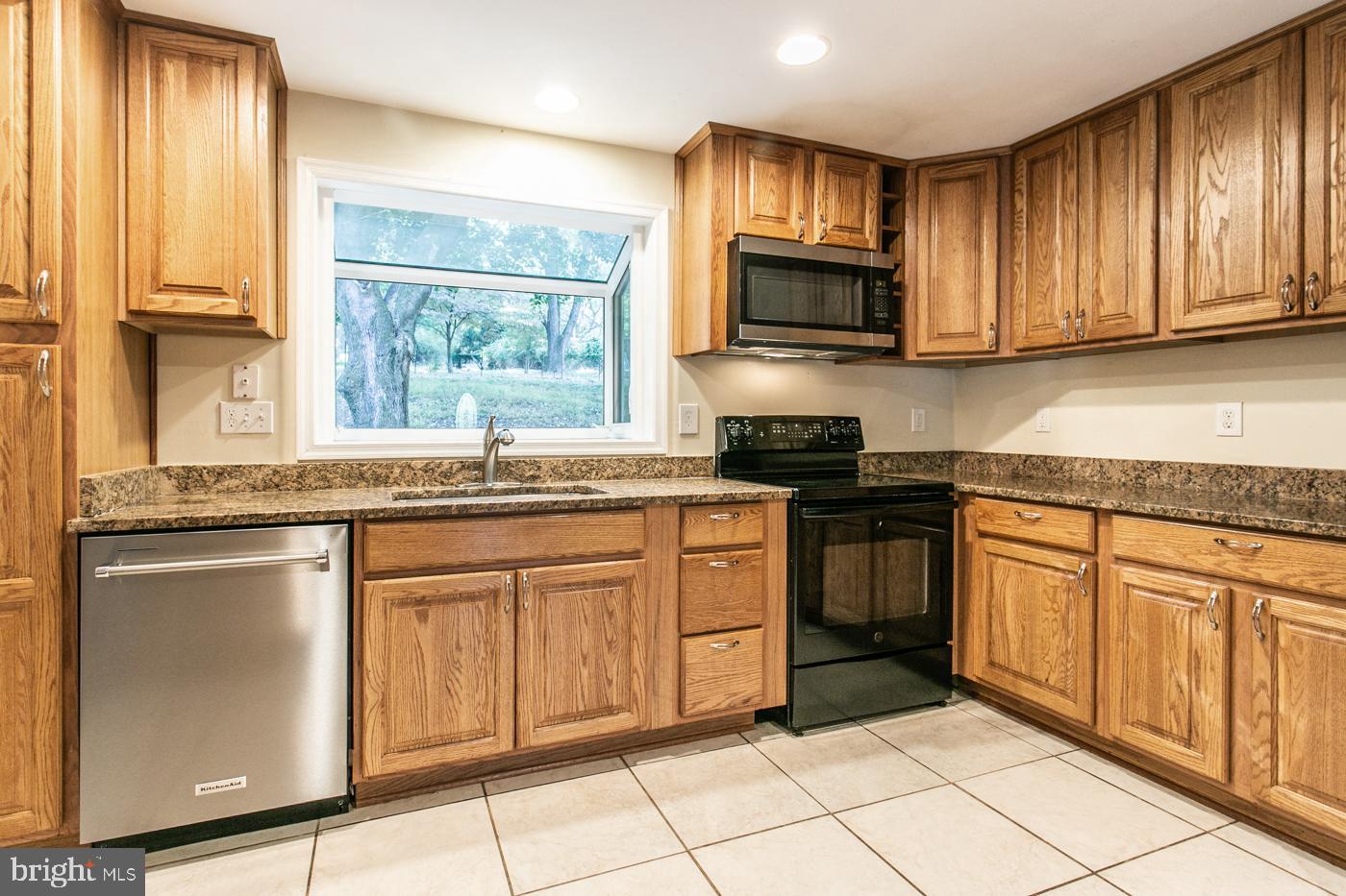 288 Devonshire Road Devon, PA 19333 - Photo 15 of 48 a kitchen with granite countertop a stove top oven sink and cabinets