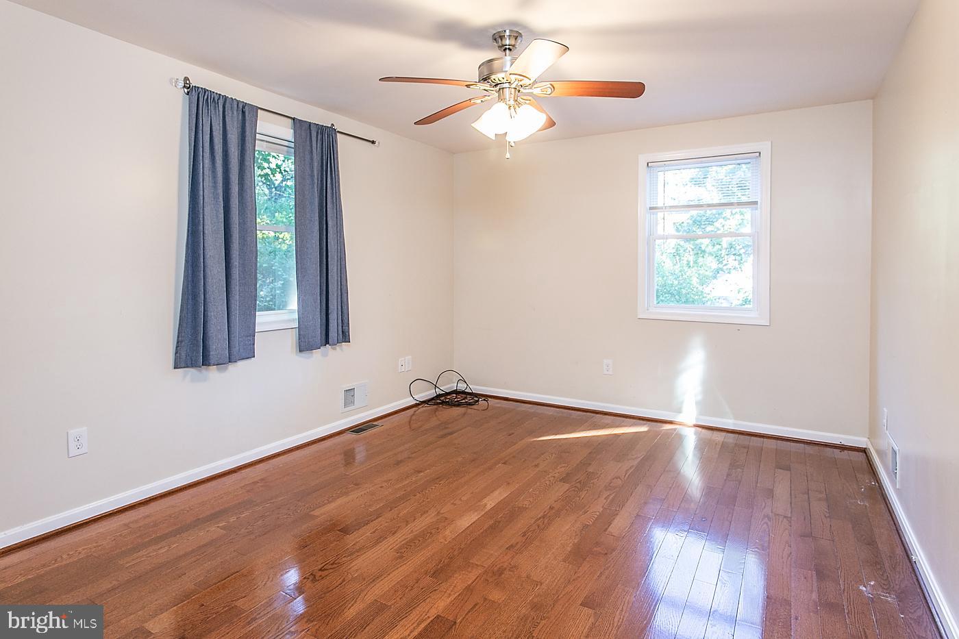 288 Devonshire Road Devon, PA 19333 - Photo 27 of 48 an empty room with wooden floor chandelier fan and windows