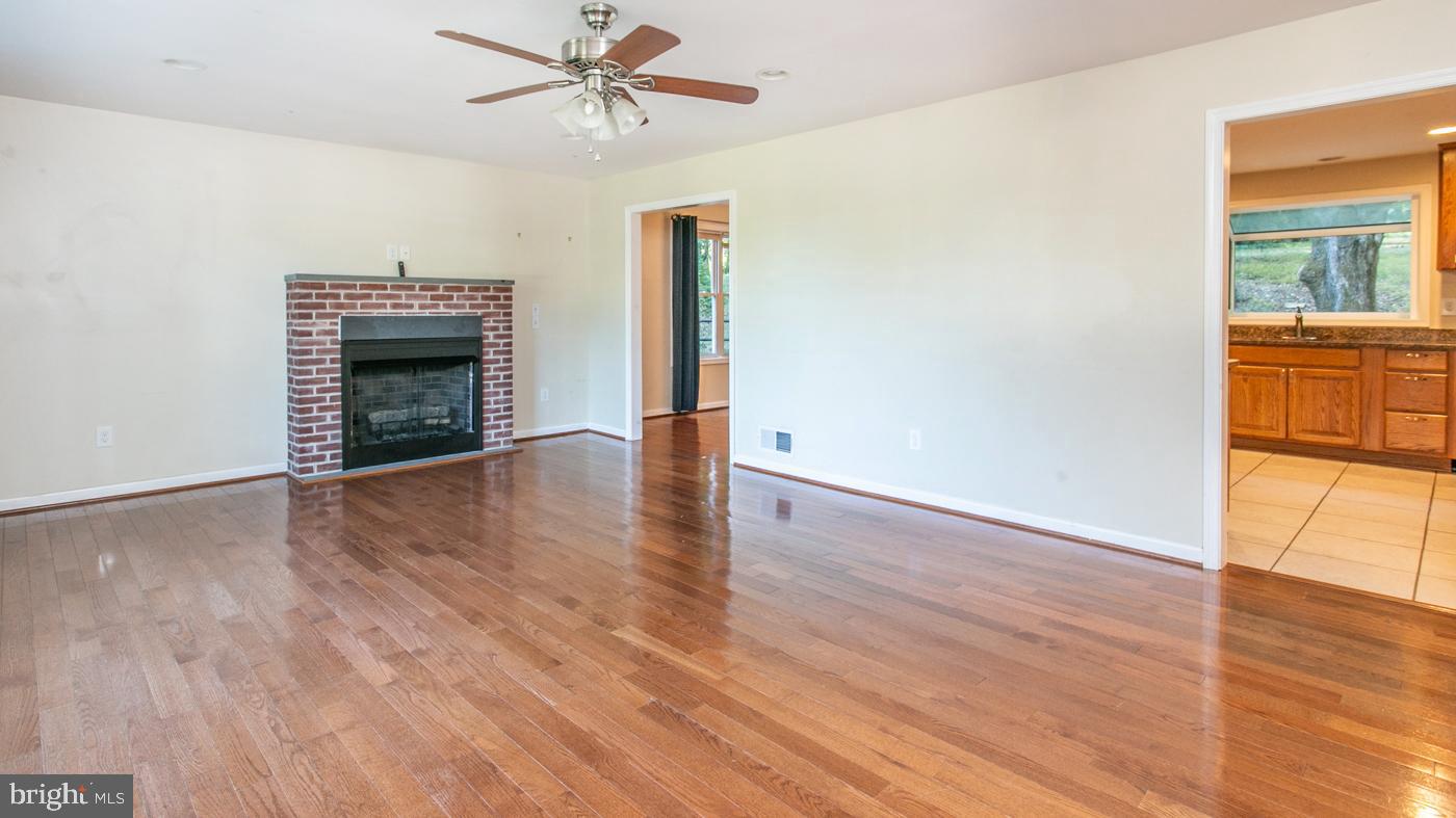 288 Devonshire Road Devon, PA 19333 - Photo 6 of 48 an empty room with wooden floor fireplace and windows