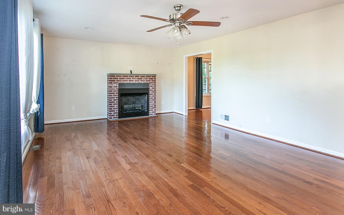 288 Devonshire Road Devon, PA 19333 - Photo 7 of 48 an empty room with wooden floor fireplace and windows