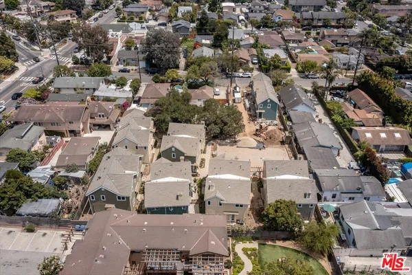 a view of a brick house with a yard and large trees