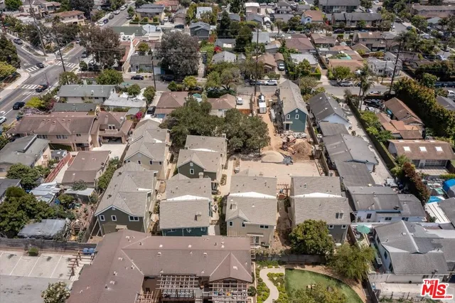 a view of a brick house with a yard and large trees