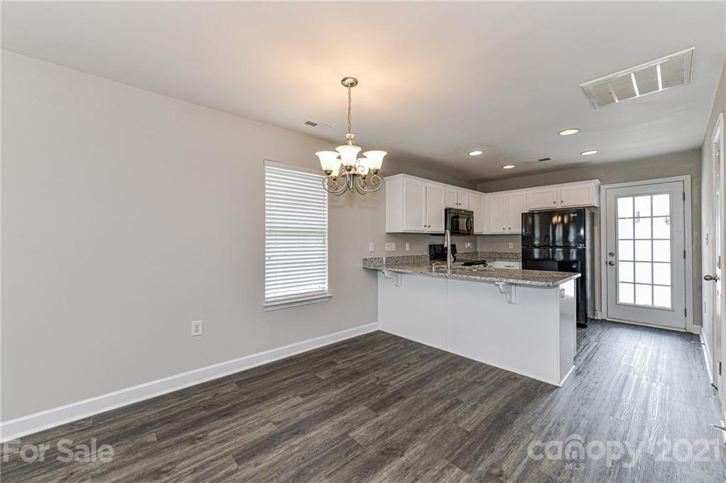 1894 Sandal Brook Road Indian Land, SC 29707 - Photo 10 of 30 a kitchen with stainless steel appliances granite countertop a refrigerator a sink dishwasher a stove and white cabinets with wooden floor