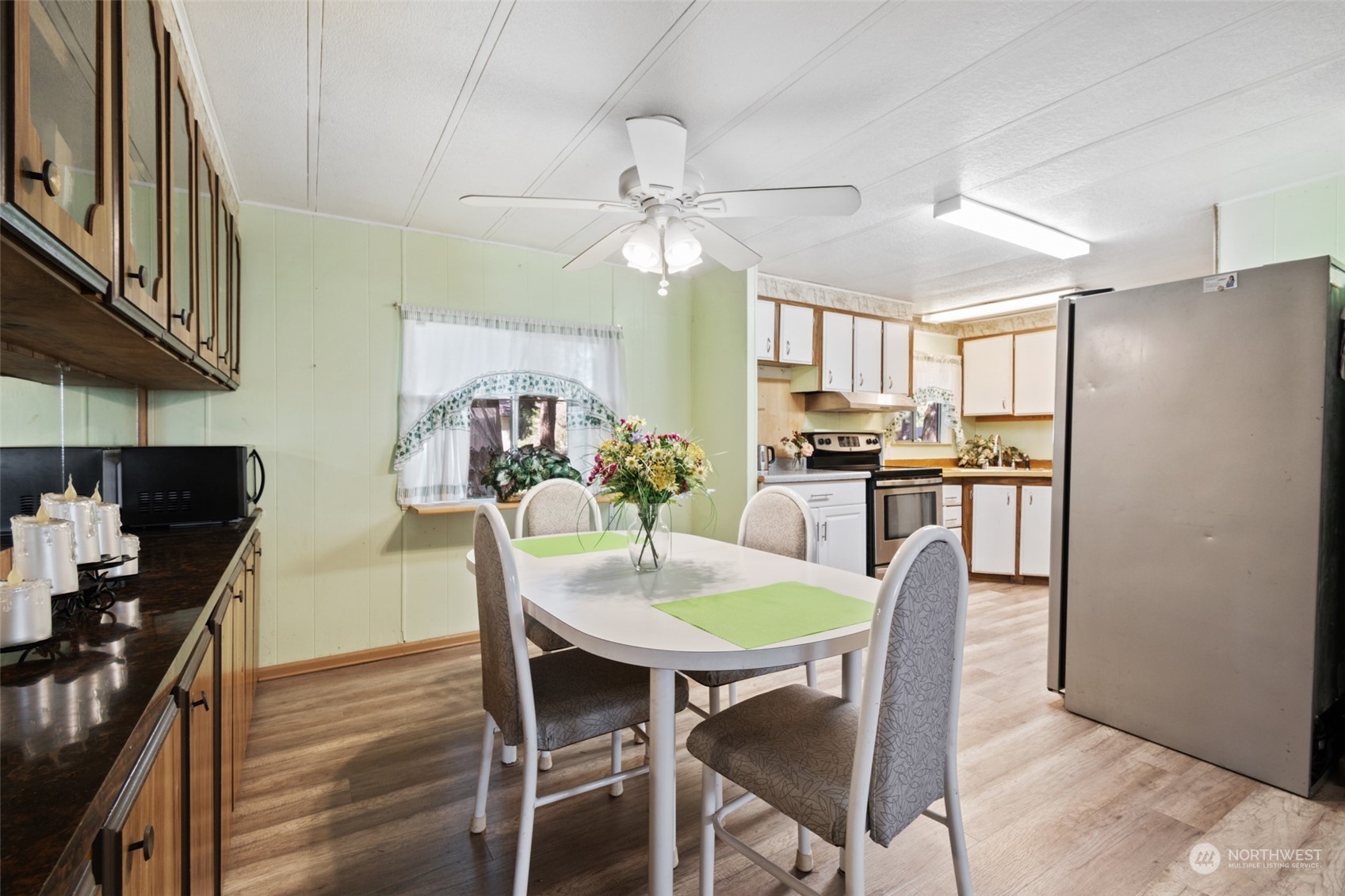 8117 176th Avenue Southwest Rochester, WA 98579 - Photo 11 of 27 a view of a dining room with furniture a kitchen and chandelier