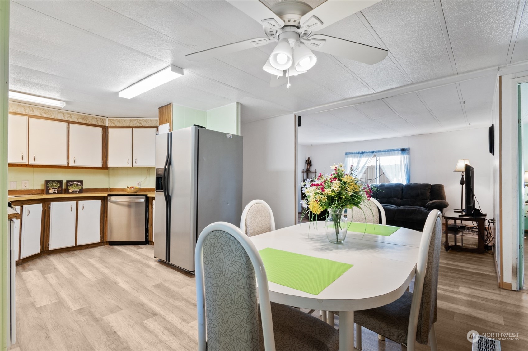 8117 176th Avenue Southwest Rochester, WA 98579 - Photo 13 of 27 a kitchen with stainless steel appliances kitchen island granite countertop a dining table chairs and a refrigerator