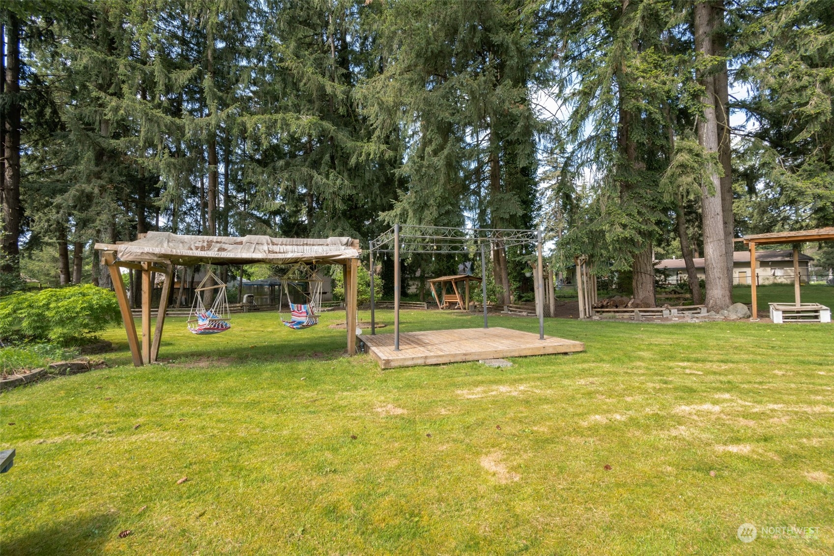 8117 176th Avenue Southwest Rochester, WA 98579 - Photo 6 of 27 a view of a swimming pool with lawn chairs and large trees