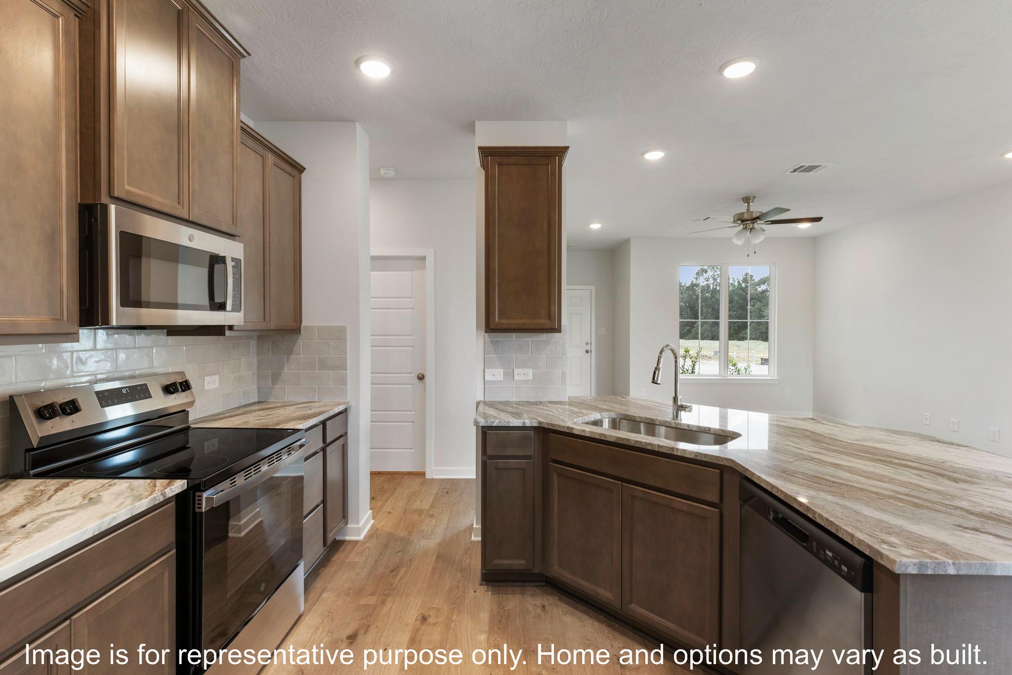 228 Gus Loop Georgetown, TX 78626 - Photo 11 of 16 a kitchen with stainless steel appliances granite countertop a sink stove and cabinets