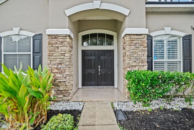 a front view of a house with plants