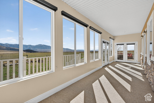4768 East Hickman Canyon Road Stockton, UT 84071 - Photo 53 of 85 Sunroom with a mountain view, carpet floors, and french doors.