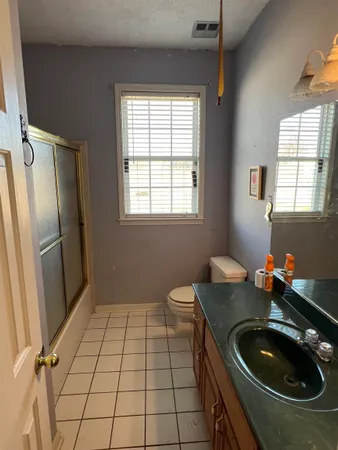 a bathroom with a sink a toilet and a window