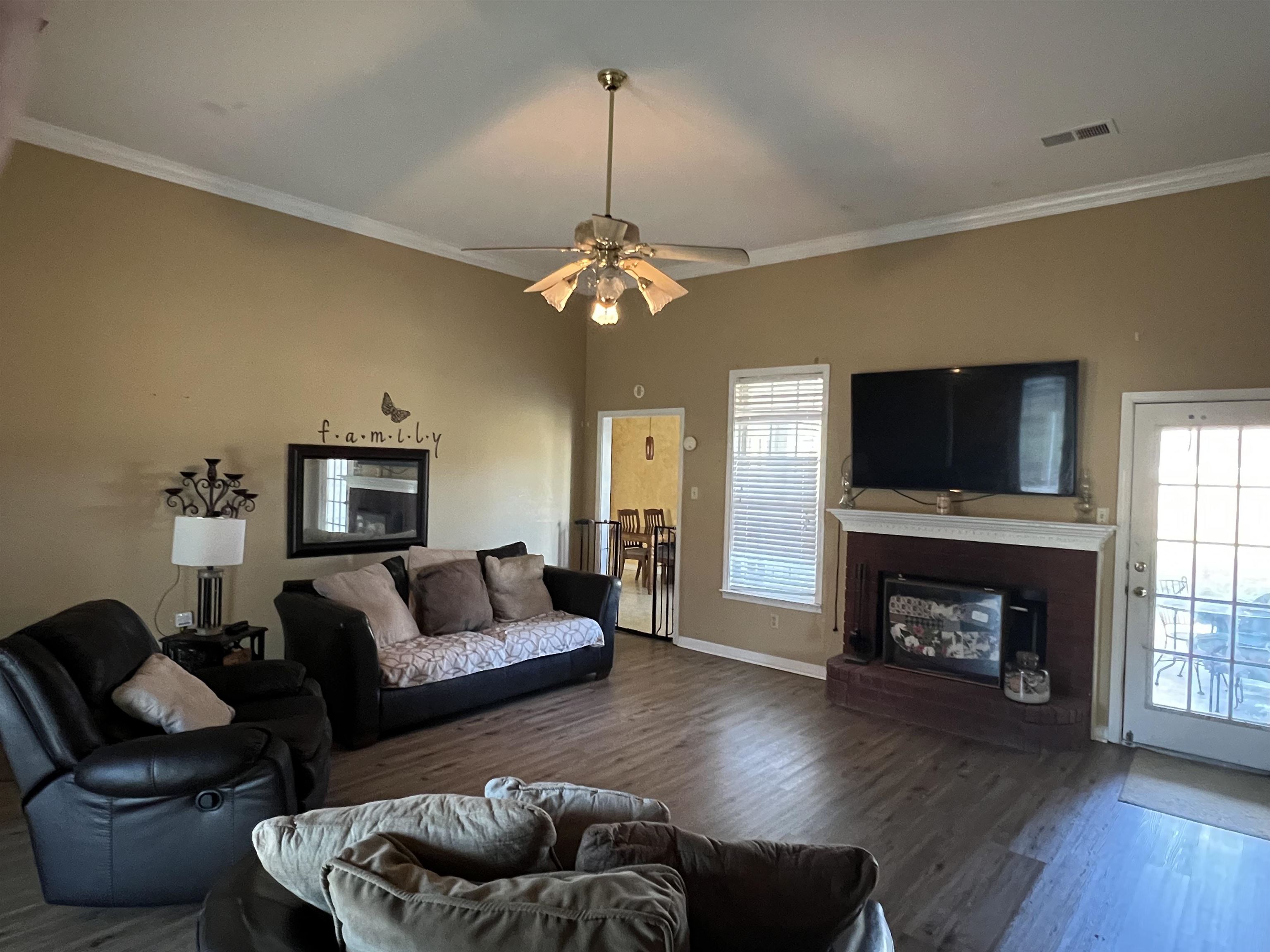 1990 Gainsville Road Mason, TN 38049 - Photo 3 of 13 Living room with a glass covered fireplace, wood finished floors, ornamental molding, and ceiling fan