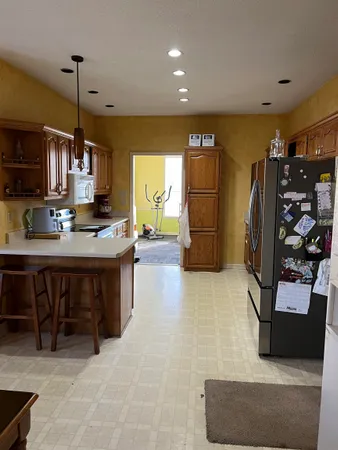 a kitchen with stainless steel appliances granite countertop a refrigerator and a stove top oven