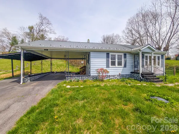 a view of a house with backyard and a tree