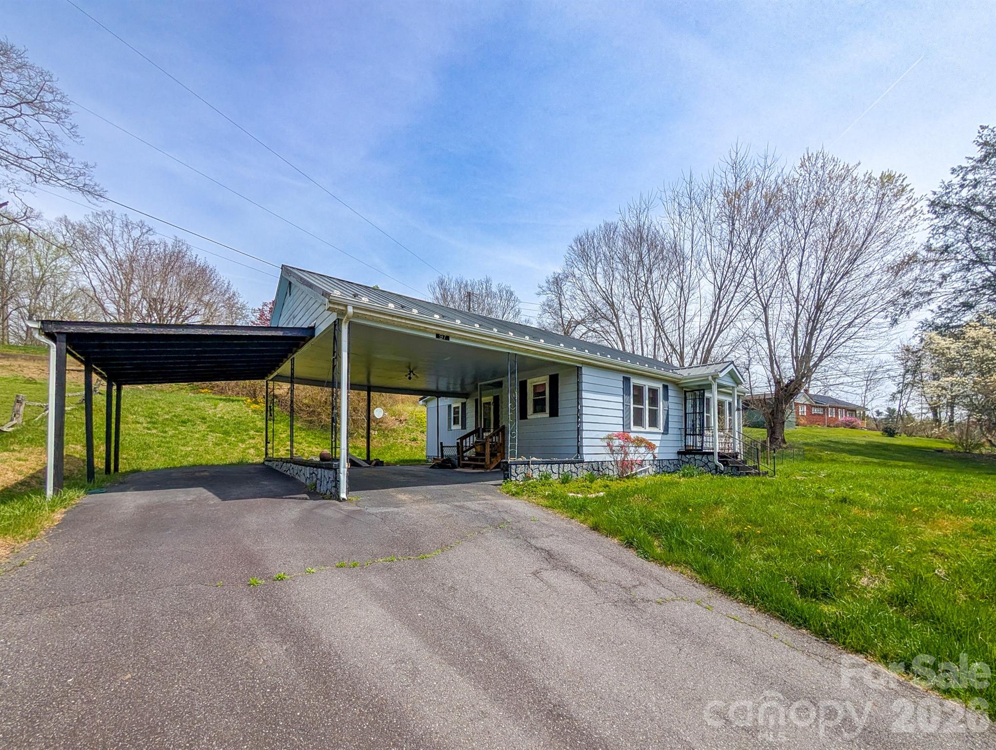 97 Tom Sparks Road Spruce Pine, NC 28777 - Photo 2 of 35 a view of a house with a yard and table and chairs under an umbrella