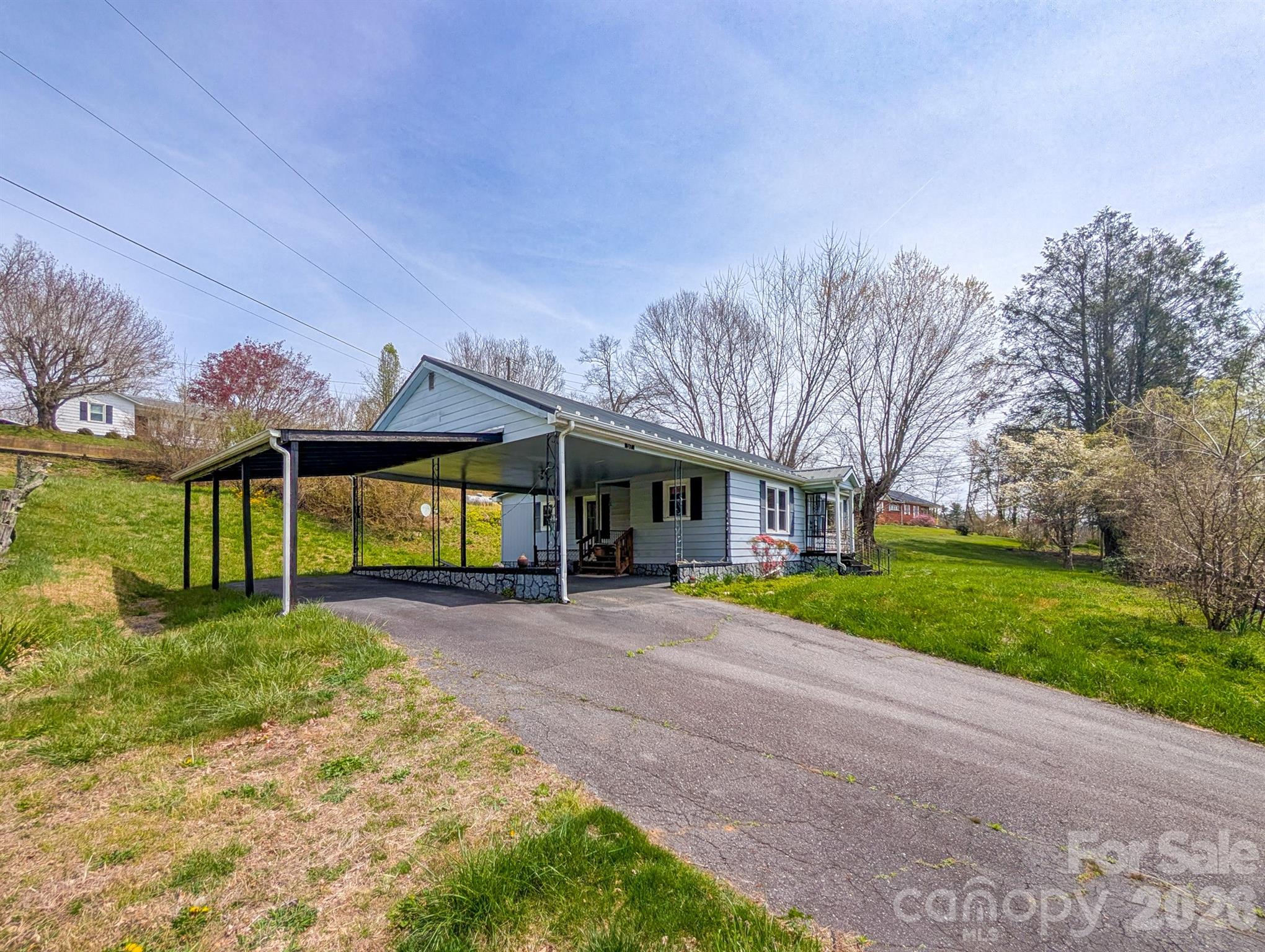 97 Tom Sparks Road Spruce Pine, NC 28777 - Photo 5 of 35 a view of a house with a big yard and large trees