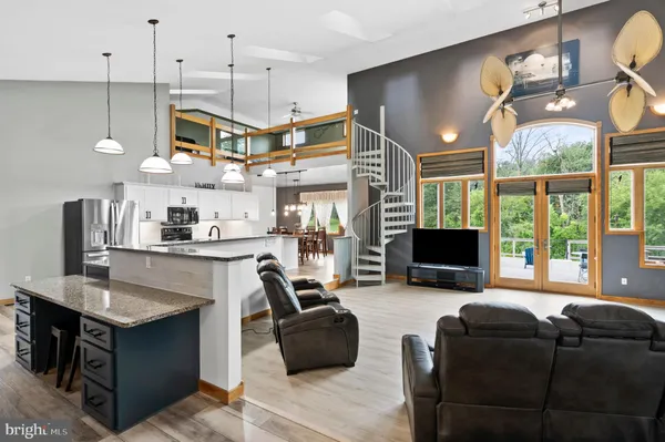 a living room with furniture a fireplace and a chandelier