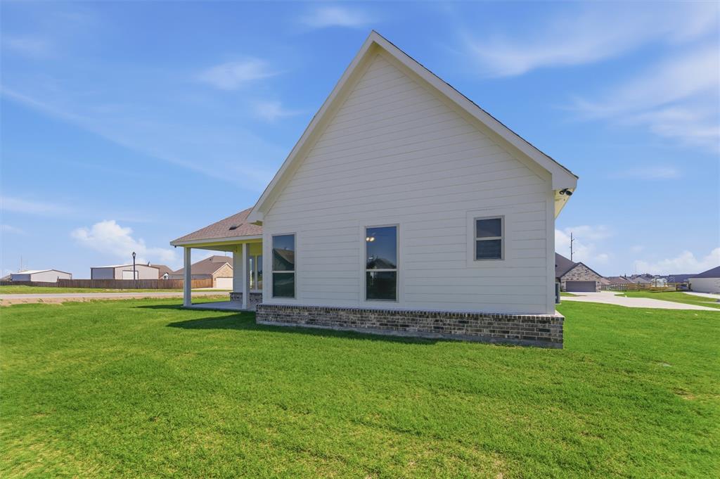 104 Snowy Owl Trail Rhome, TX 76078 - Photo 24 of 27 New construction exterior featuring white siding and a brick skirting