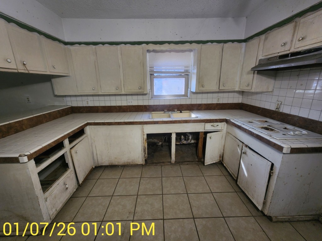 230 Kansas Street Bacliff, TX 77518 - Photo 2 of 16 a kitchen with a sink a stove and cabinets