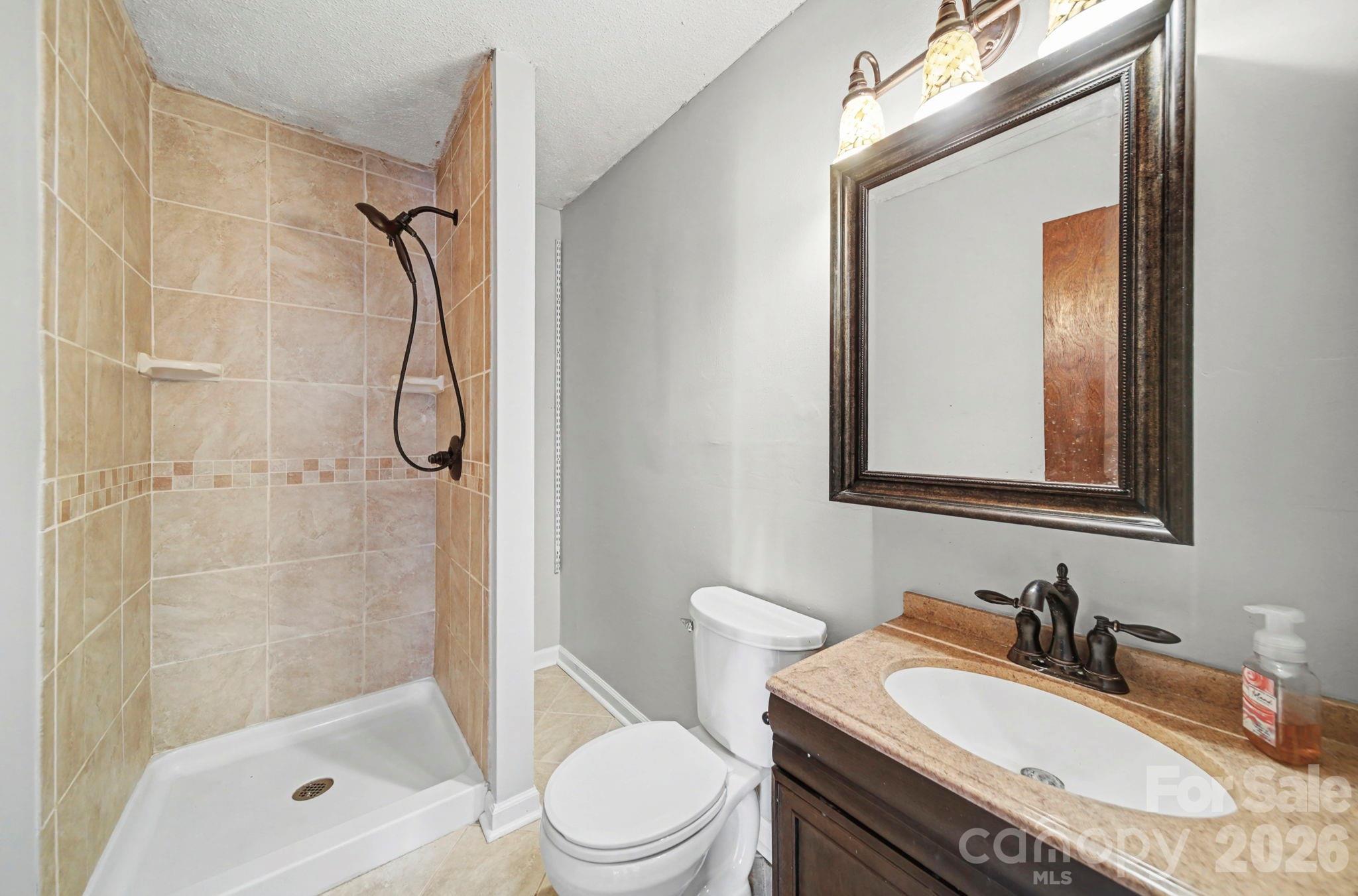 102 Roxie Lane Belmont, NC 28012 - Photo 11 of 26 a bathroom with a granite countertop sink toilet mirror and shower