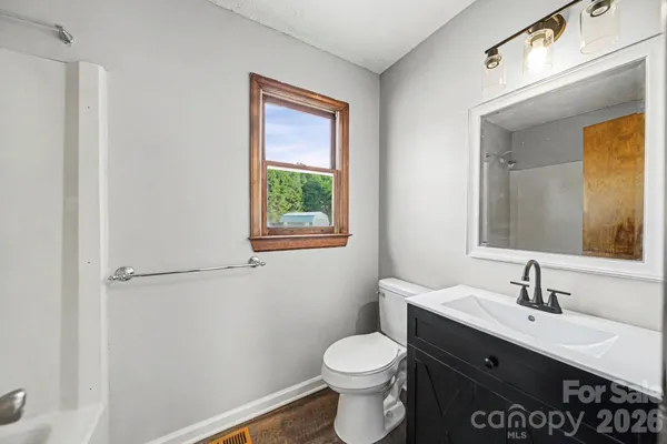 a bathroom with a sink a toilet and mirror