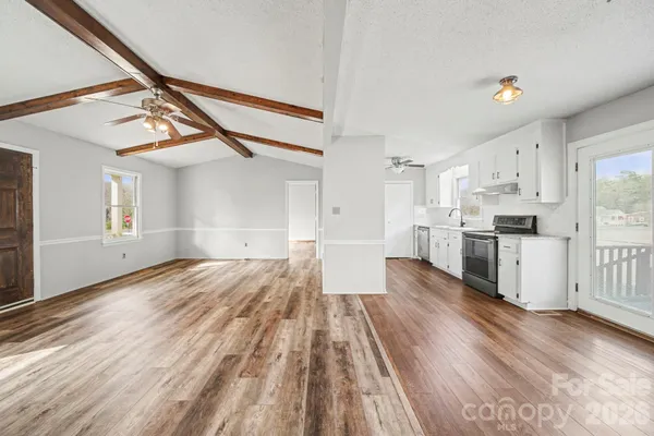 a view of kitchen with wooden floor and electronic appliances