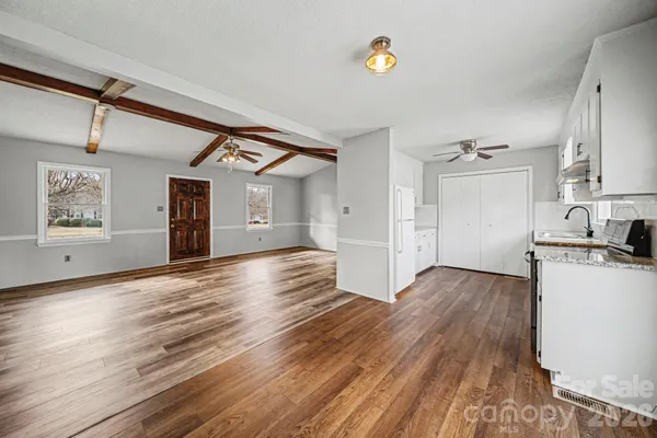 a view of a kitchen with wooden floor a sink and windows