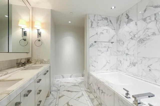 a bathroom with a bathtub sink and mirror