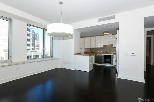 a kitchen with stainless steel appliances wooden floors and white cabinets