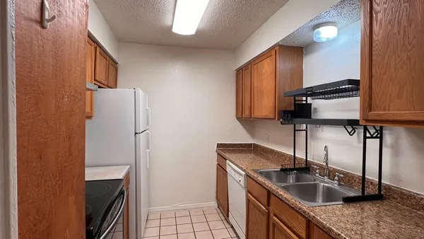 a kitchen that has a sink a refrigerator and a sink