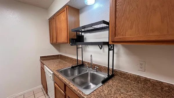 a kitchen with stainless steel appliances granite countertop a sink and a refrigerator