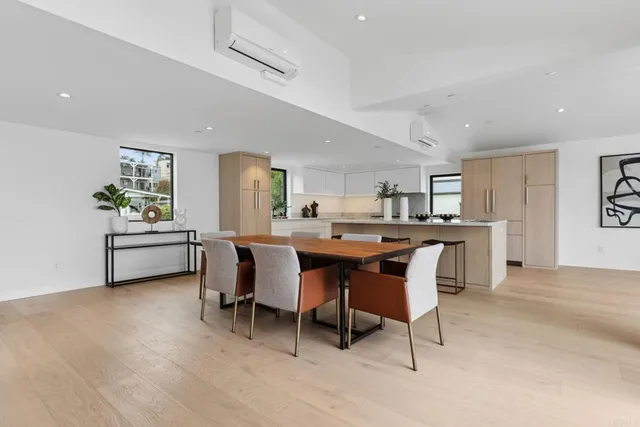 a living room with stainless steel appliances kitchen island granite countertop lots of white furniture a dining table and chairs