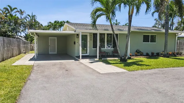 a view of a house with a yard and palm trees