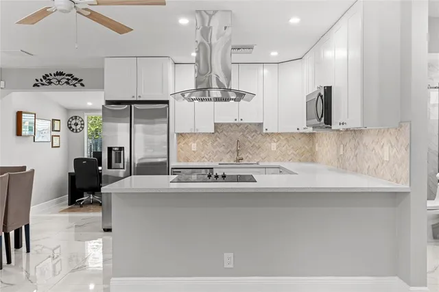 a large kitchen with a table chairs refrigerator and microwave