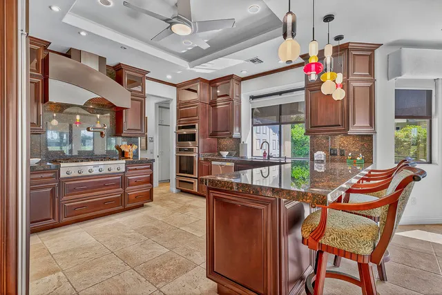 a kitchen with stainless steel appliances granite countertop a stove a sink and a refrigerator